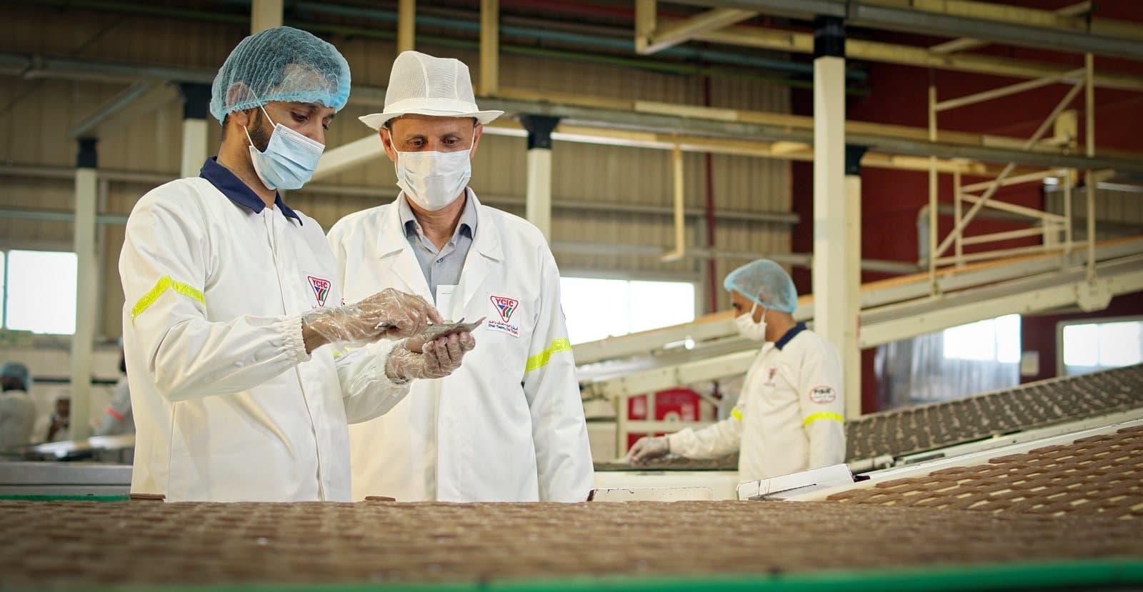 Quality staff inspecting biscuits on the YCIC production line in Taiz — HSA Group’s manufacturing